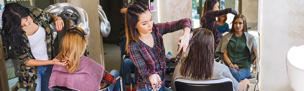 Working day inside the hair salon, hairdressers making hairstyle