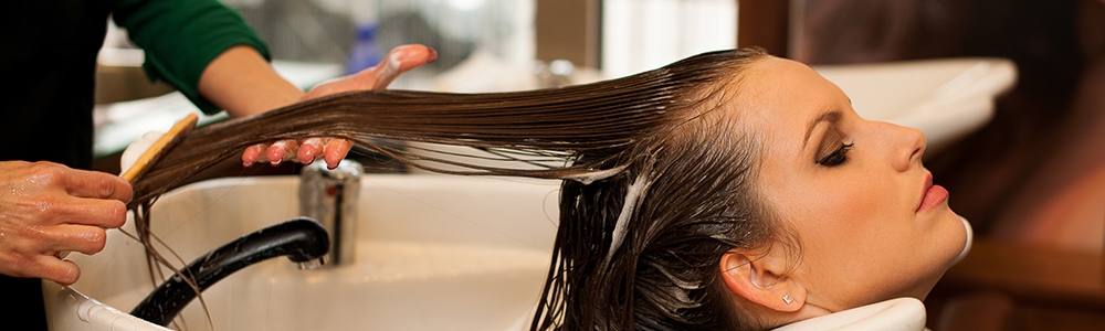 Hairdresser making hair treatment to a customer in salon